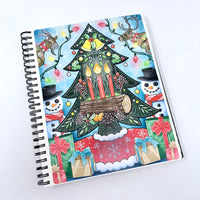 Decorative notebook with Christmas-themed cover featuring a tree, candles, and presents on a white background.